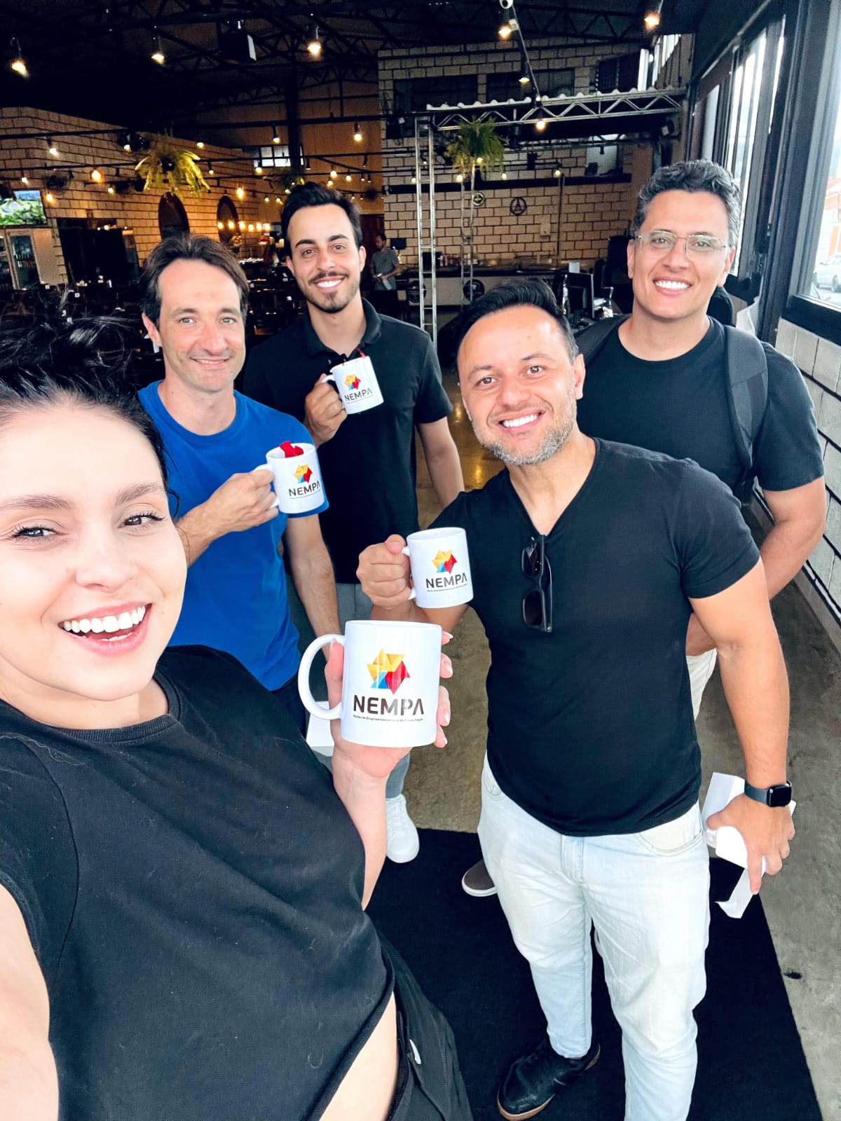 Equipe do NEMPA reunida com as canecas do núcleo